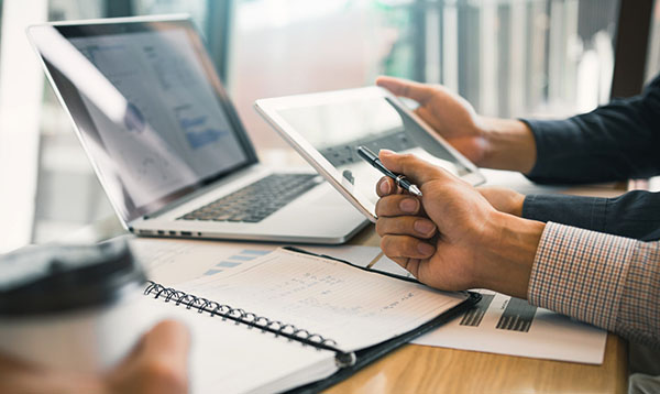 Business partnership coworkers using a tablet to chart company f Skiply, the real world at the heart of your Business Information System